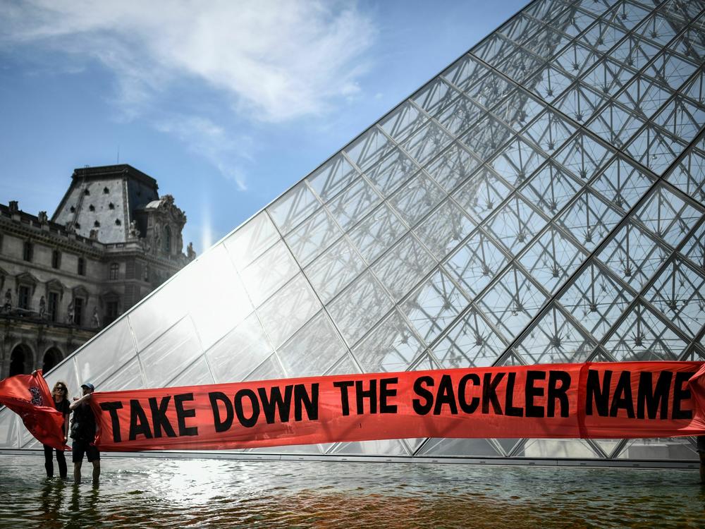 Activists hold a banner reading 