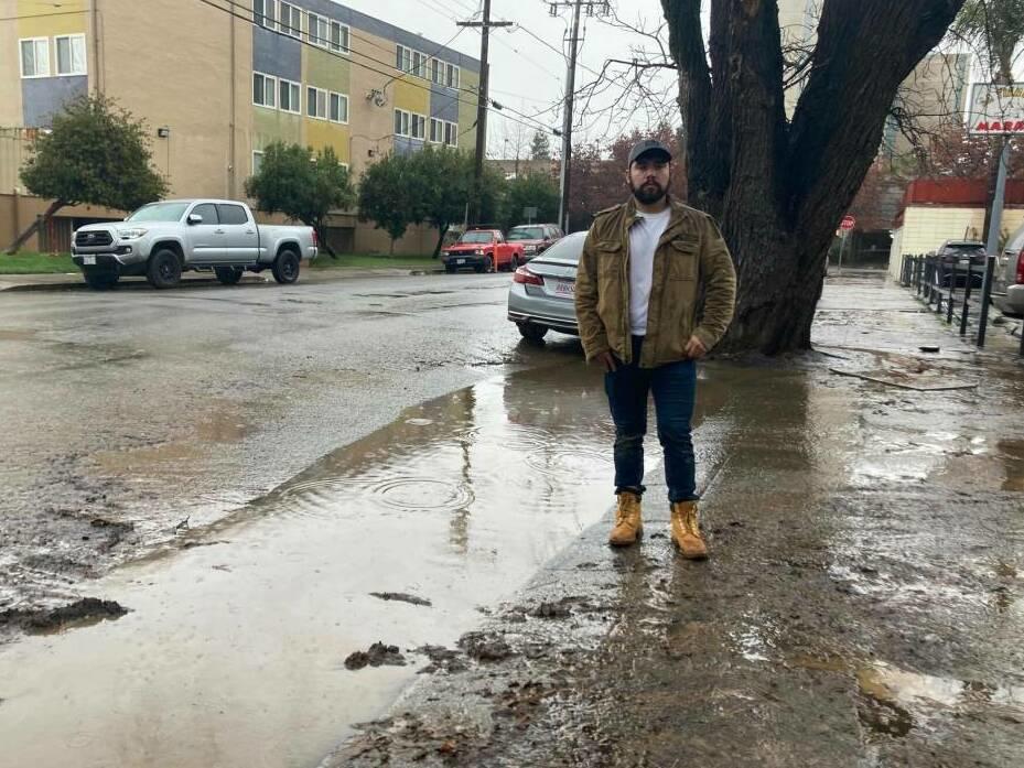 Antonio López, East Palo Alto's vice mayor, stands next to floodwaters in the city.