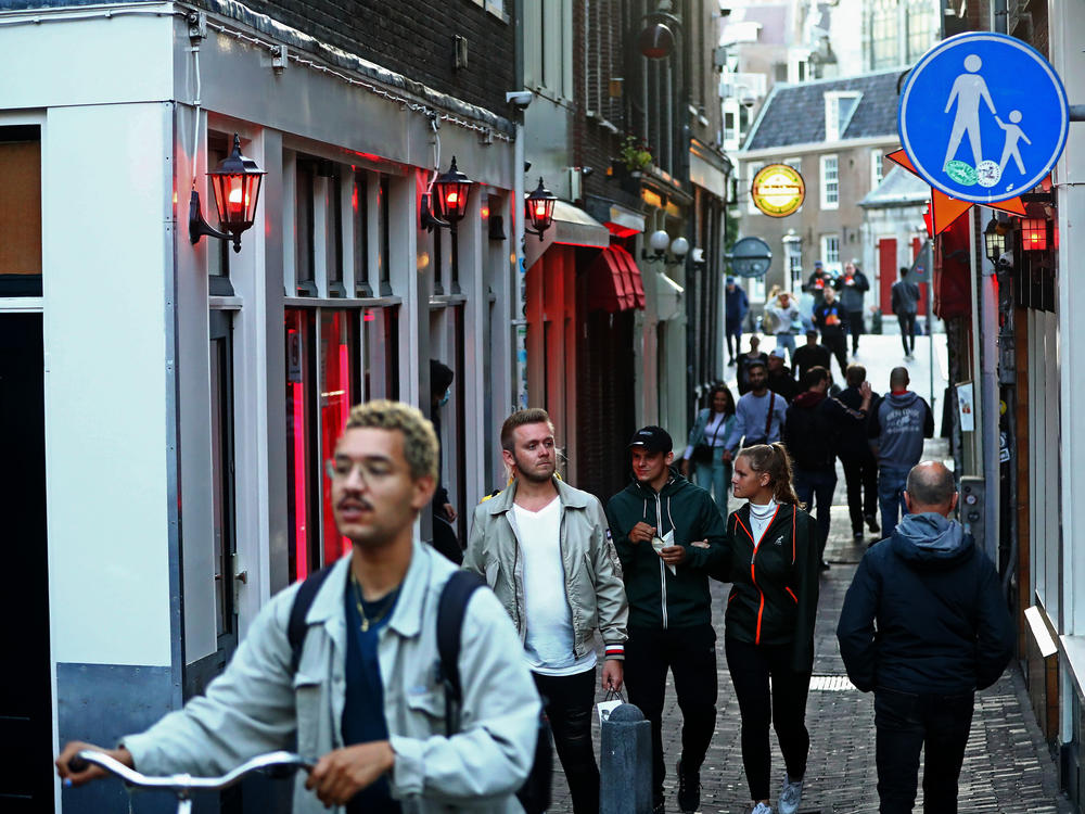 People walk through Amsterdam's red-light district shortly after it reopened in 2020, during the pandemic. The neighborhood attracts millions of tourists each year.