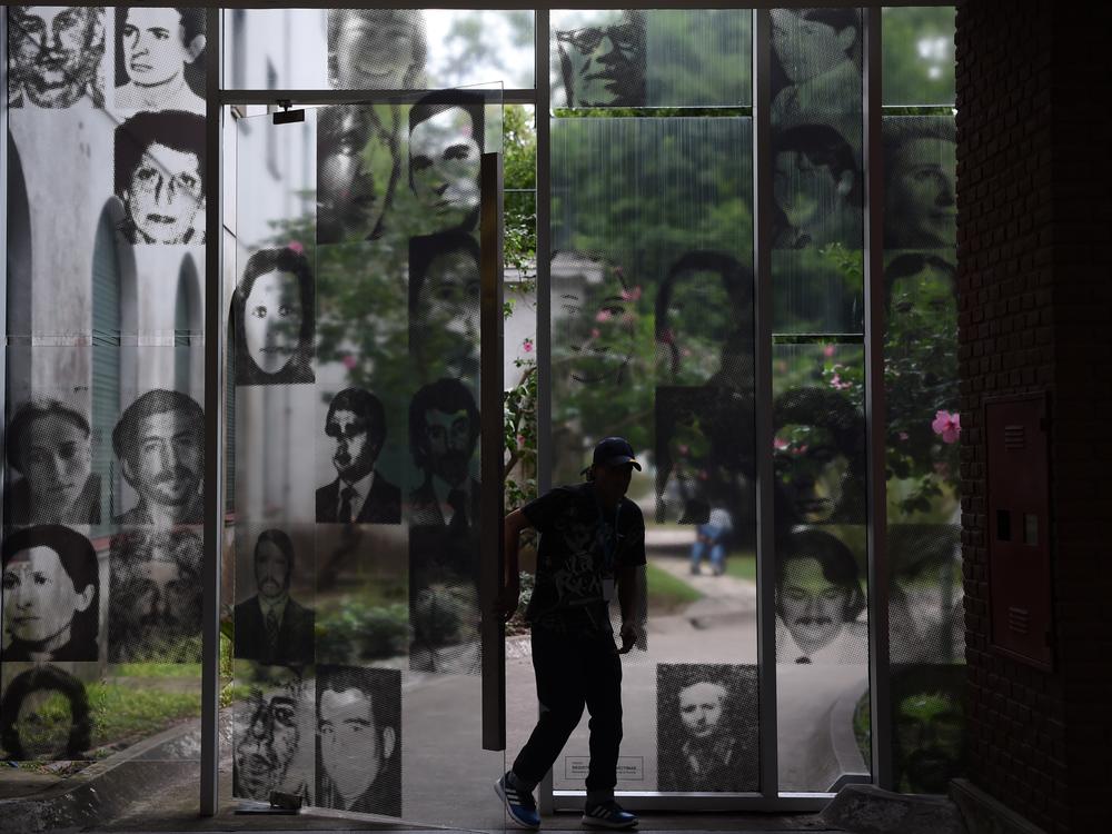 A visitor enters the Officers Casino building at ESMA on March 19, 2016. The windows are filled with images of civilians who were tortured and killed here.