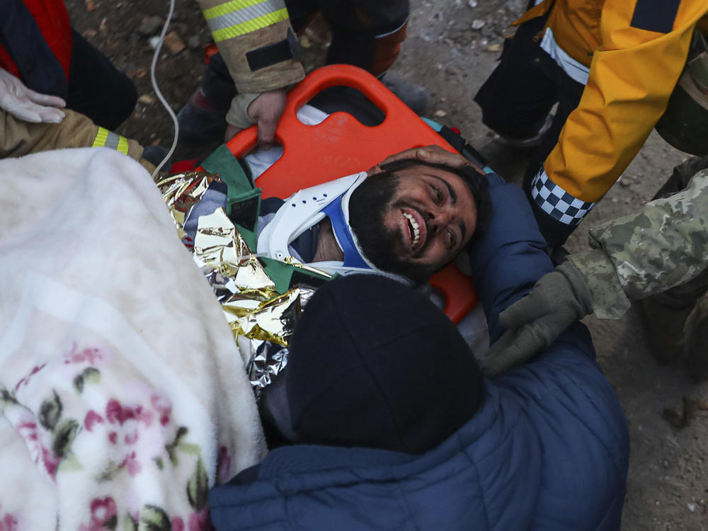 Turkish rescue workers carry Ergin Guzeloglan, 36, to an ambulance on Saturday after pulling him out of a collapsed building in Hatay, southern Turkey, five days after an earthquake devastated the region.