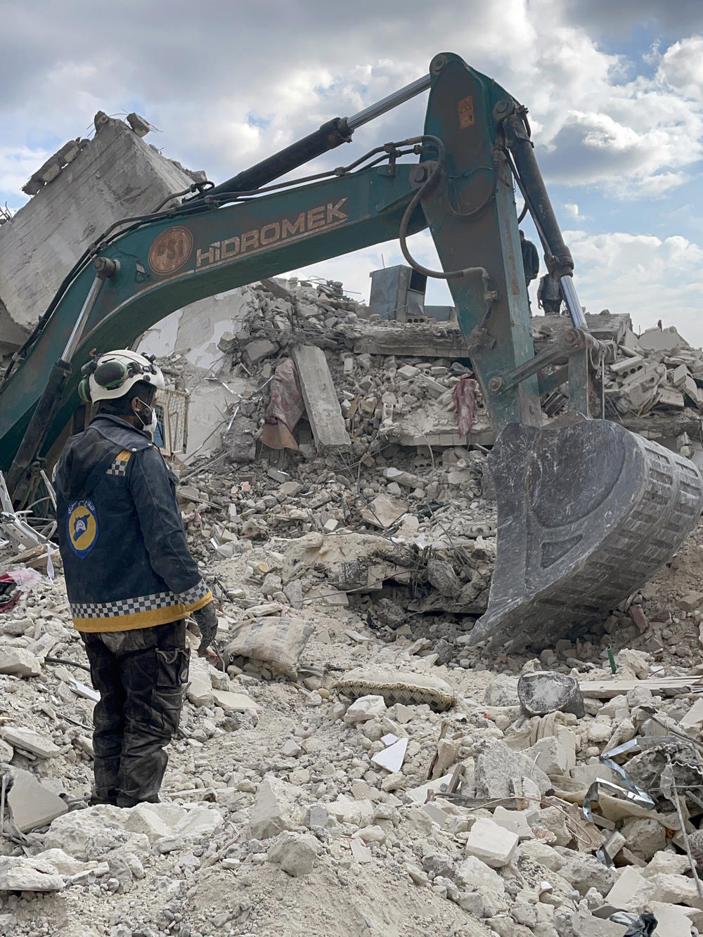 Syrian civil defense workers in the town of Jinderis dig through the rubble of a collapsed residential building in search for a 13-year-old boy and four other people on Friday.