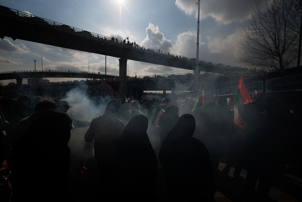 Incense from the burning of wild rue seeds called Esphand in Persian wafts over the crowd during Revolution Day celebrations in Tehran.