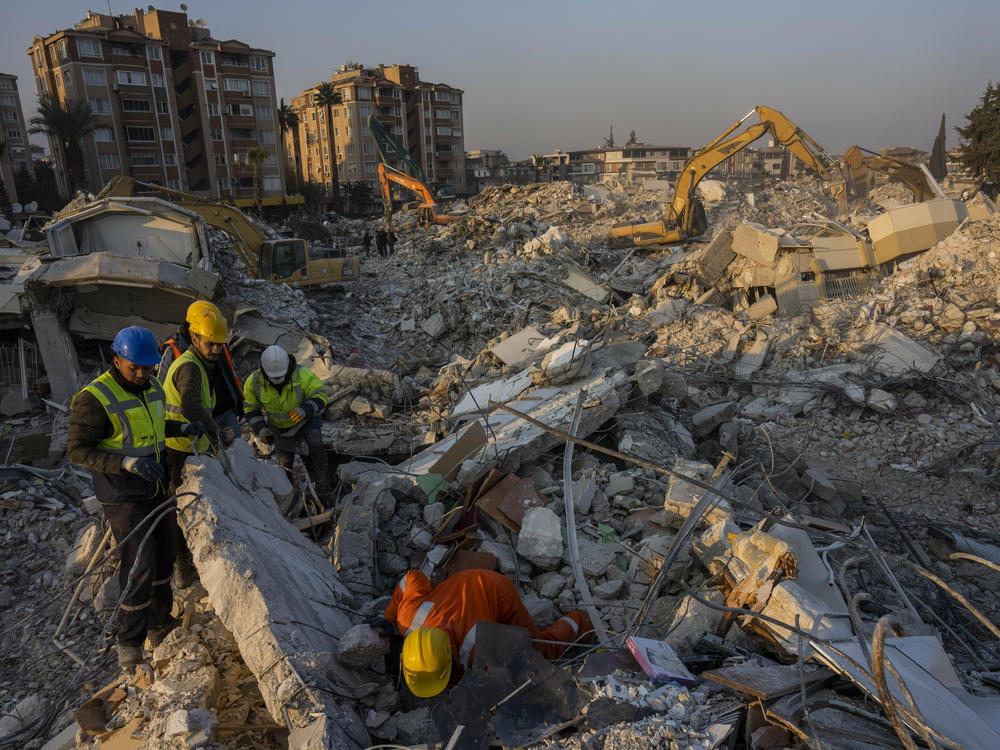 Members of a search and rescue operation work Sunday on an area that collapsed during the earthquake in Antakya, in southeastern Turkey. Disaster recovery experts say ordinary people are crucial to saving lives.