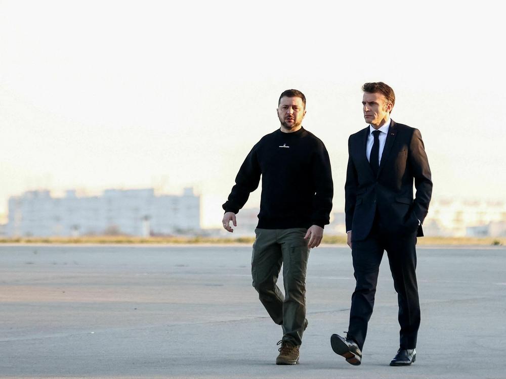 Ukrainian President Volodymyr Zelenskyy (left) walks with French President Emmanuel Macron on the tarmac of Vélizy-Villacoublay airbase as they prepare to board a flight together, en route to Brussels for a summit at European Parliament, on Feb. 9. Zelenskyy made a surprise Europe tour last week.