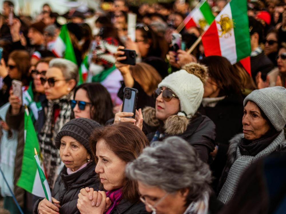 People listen to a speaker during a demonstration to denounce the Iranian government and express support with anti-government protesters in Iran, in Washington, DC.