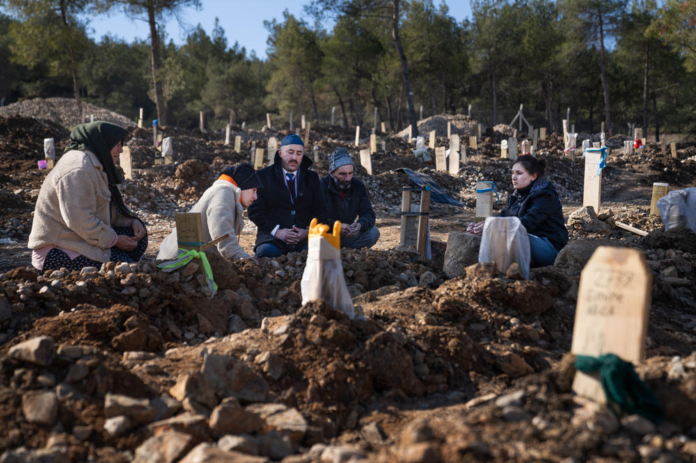 Grief-stricken mourners visit the cemetery. Some funerals have a few family members while others have dozens of relatives in attendance.