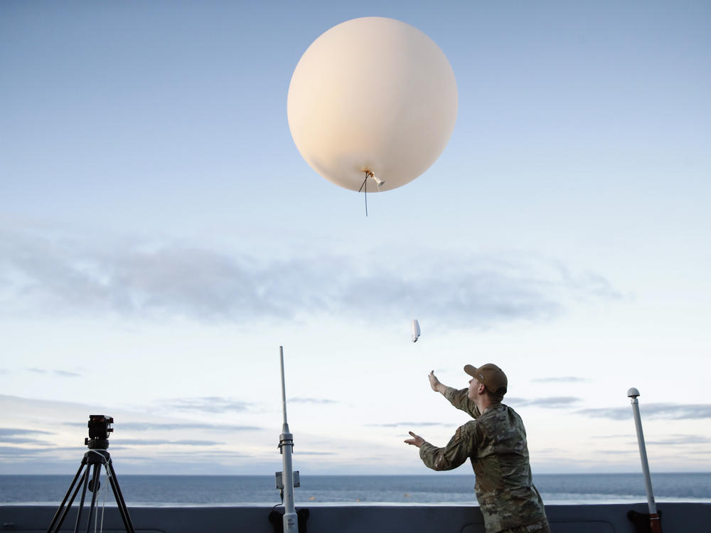 A U.S. Air Force member releases a weather balloon from the deck of the U.S.S. Portland off the coast of Baja California, Mexico, in December 2022.