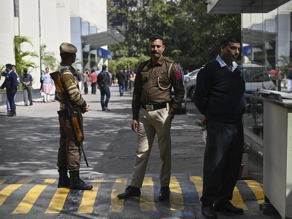 A police officer stands at the entrance of the office building where Indian tax authorities raided BBC's office in New Delhi on Tuesday.