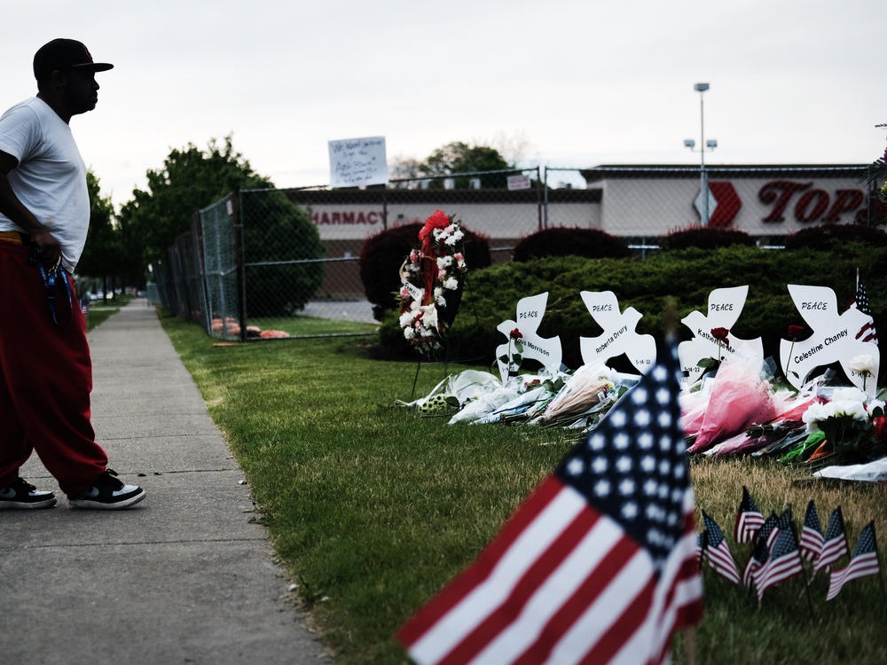 A person stands at a memorial for the victims of the May 2022 shooting at a Tops supermarket in Buffalo, N.Y.