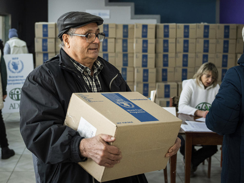 A man receives humanitarian aid provided by U.N. World Food Program and ADRA charity organization for the residents of the region and internally displaced persons at the distribution center in Kostiantynivka, Ukraine, Friday, Feb. 10, 2023.