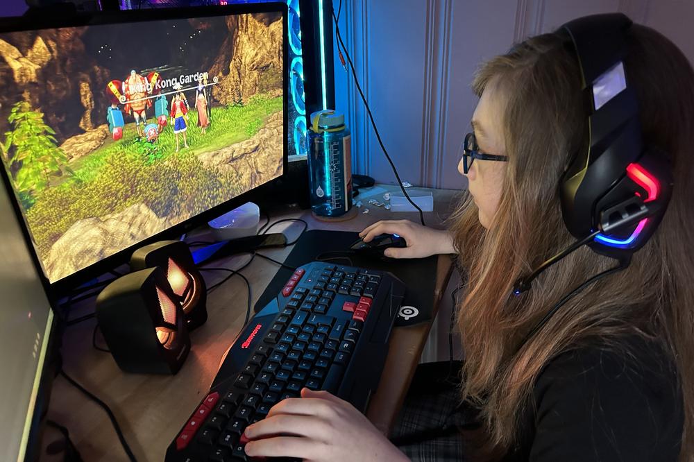 Liz Bostock playing an anime video game in her bedroom