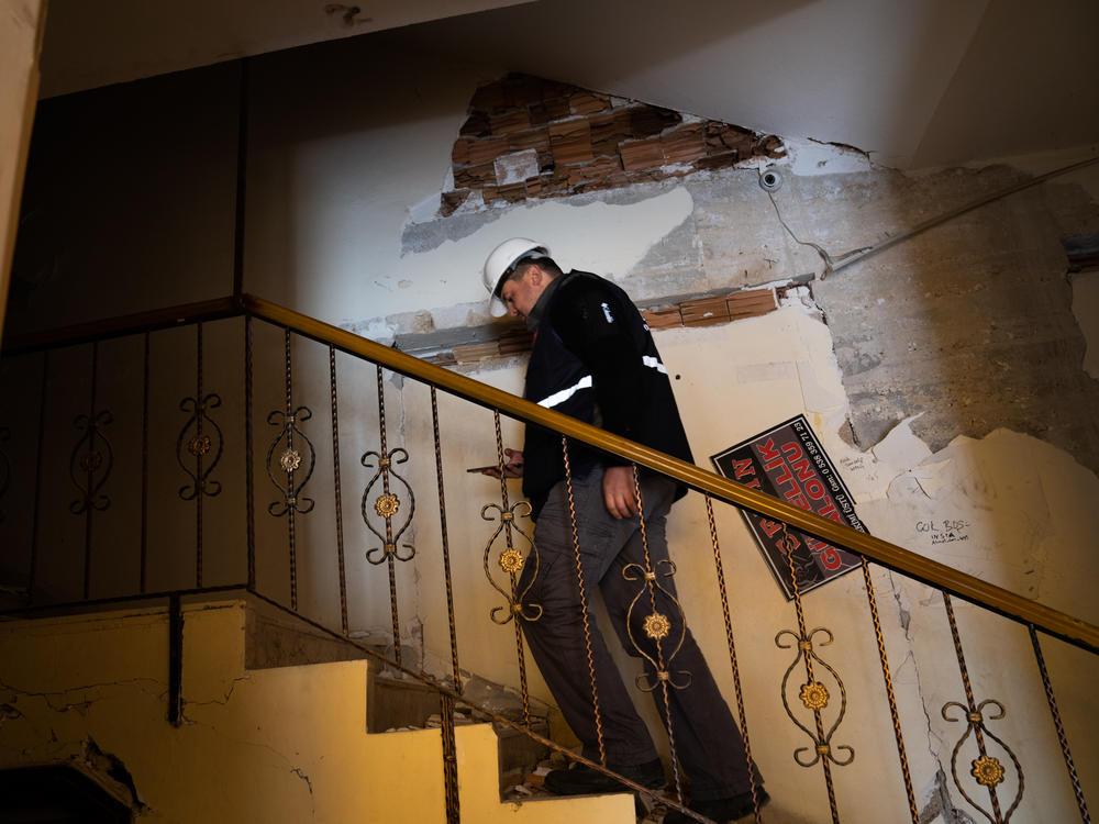 Yasin Pinarbasi walks into a building he inspected that suffered some earthquake damage, west of Antakya, Turkey.