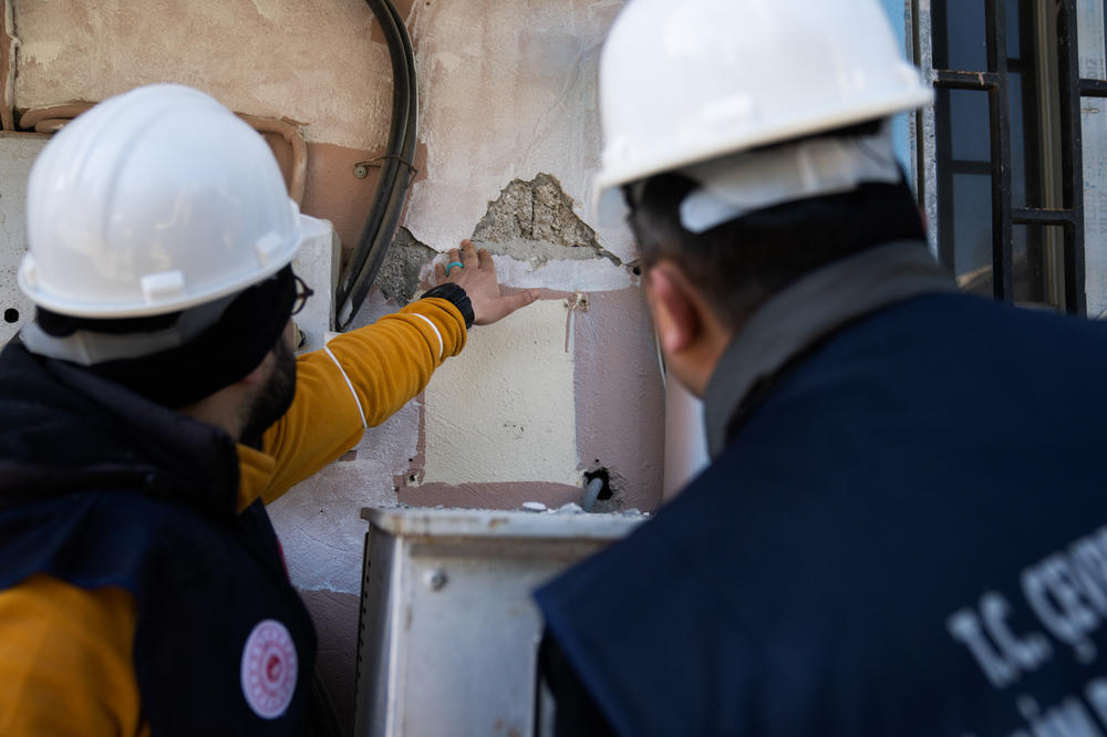 Okut and Pinarbasi inspect a crack in a support column in a building west of Antakya.