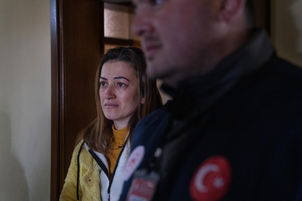 Gonul Kanar cries as she recounts her experience during the earthquake when engineer Yasin Pinarbasi comes to inspect her home.