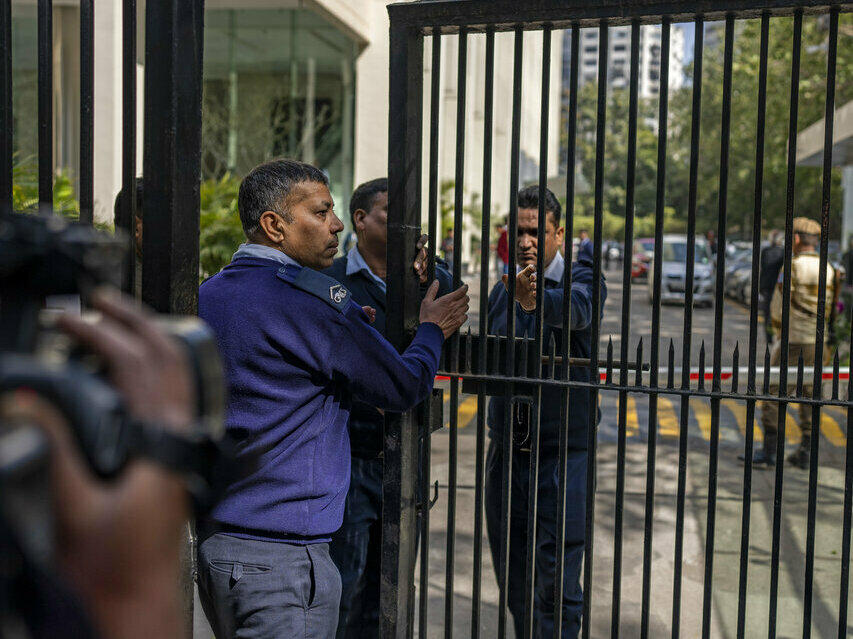 Private security guards close the gate of a building housing BBC office in New Delhi, India.