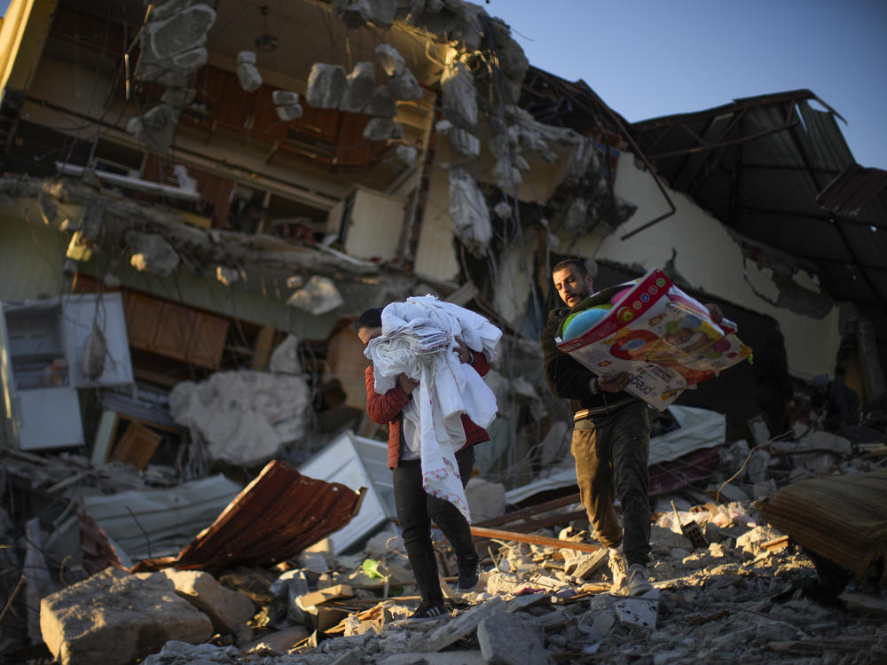 Residents remove their belongings from their destroyed house in Samandag, in southern Turkey, on Thursday. The number of people killed in the Feb. 6 earthquakes that devastated parts of southern Turkey and northern Syria continues to rise.