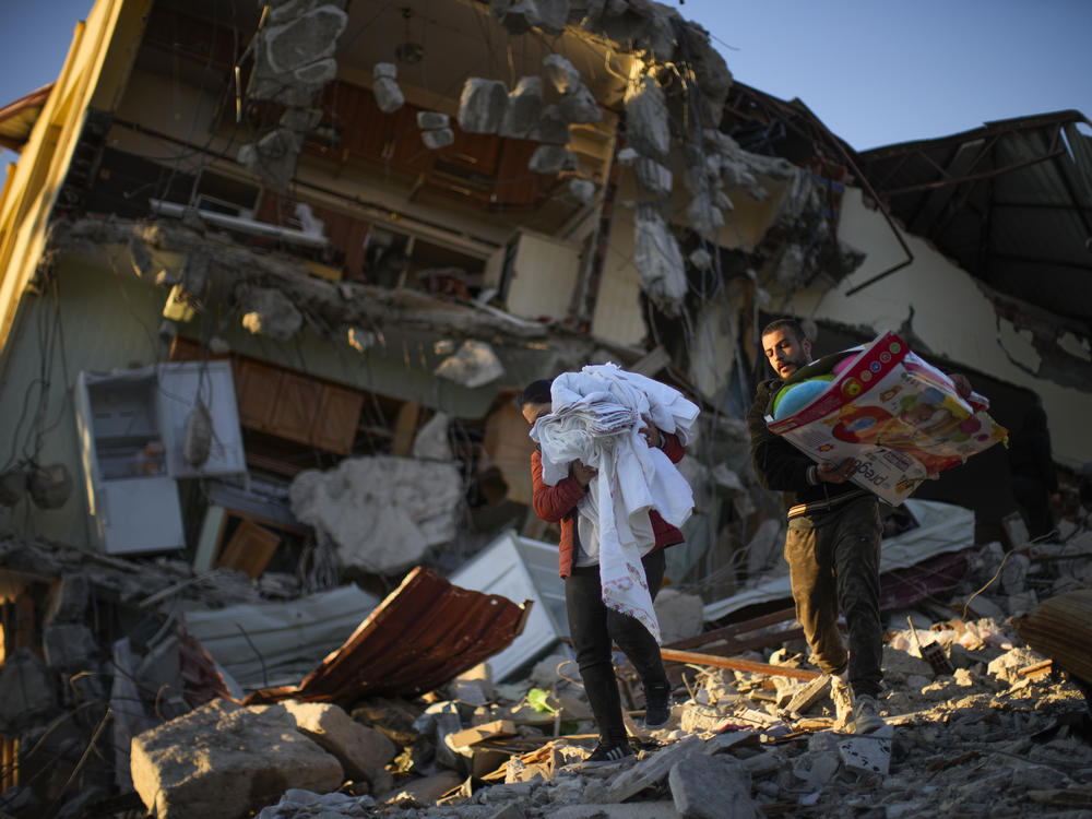 Residents remove their belongings from their destroyed house after the earthquake, in Samandag, southern Turkey, Feb. 16.