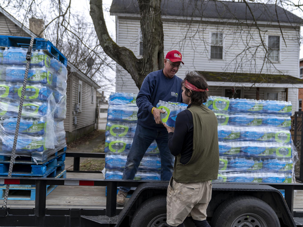 Michael Young distributes water to residents in East Palestine, Ohio, on Thursday. Authorities say municipal water sources are safe to drink following the release of chemicals in the area.