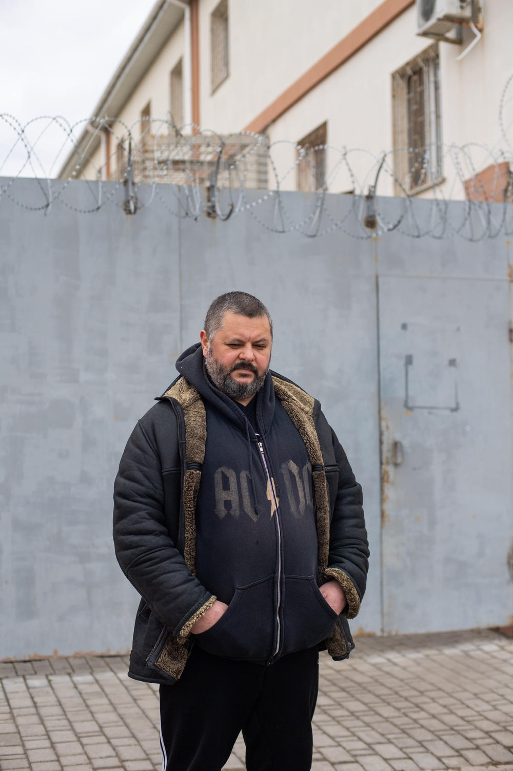 Oleksandr Diakov, a Kherson resident, poses outside the facility where he was detained and tortured by Russian forces during the occupation of the city.