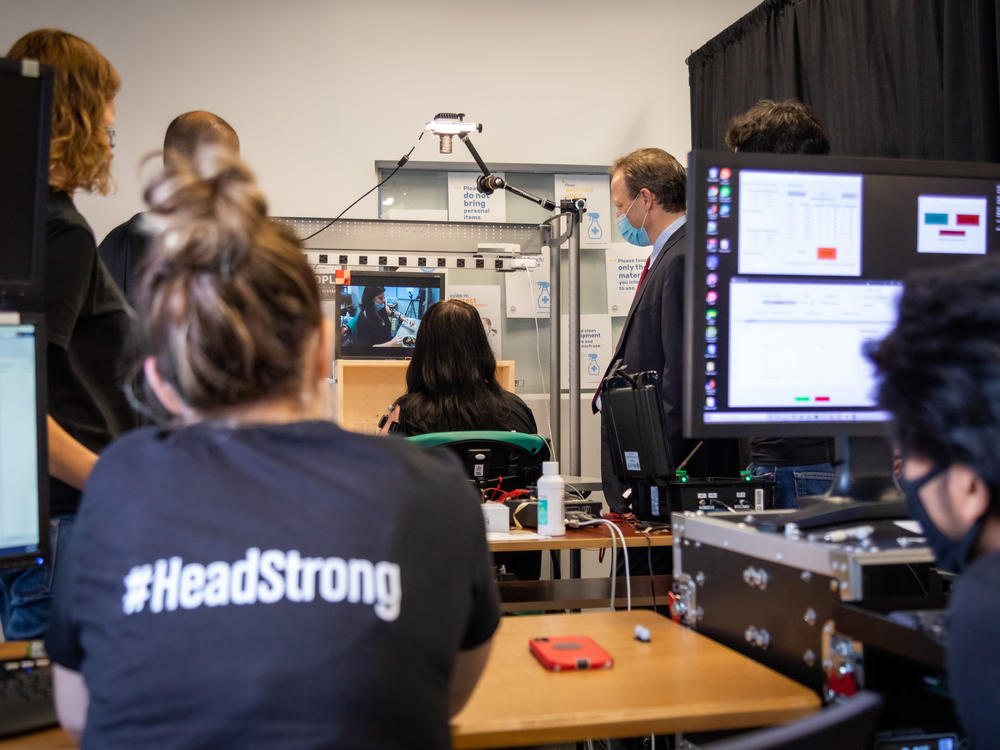 Graduate students (foreground) observe a testing procedure.