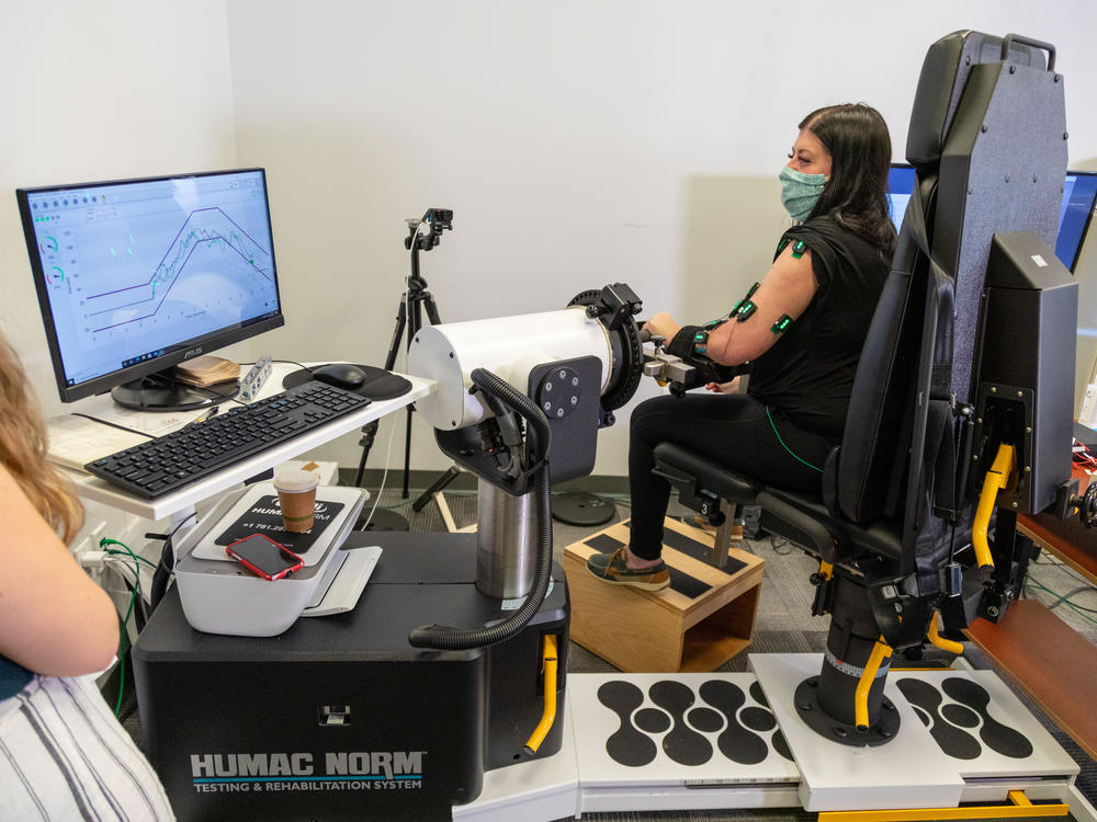 University of Pittsburgh graduate student Erynn Sorensen (left) observes research participant Rendulic during the isometric torque test used to measure arm strength.