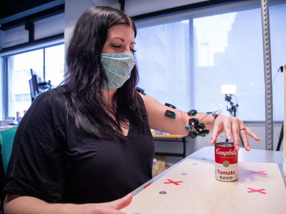 Research participant Heather Rendulic prepares to grasp and move a can of tomato soup at Rehab Neural Engineering Labs at the University of Pittsburgh.