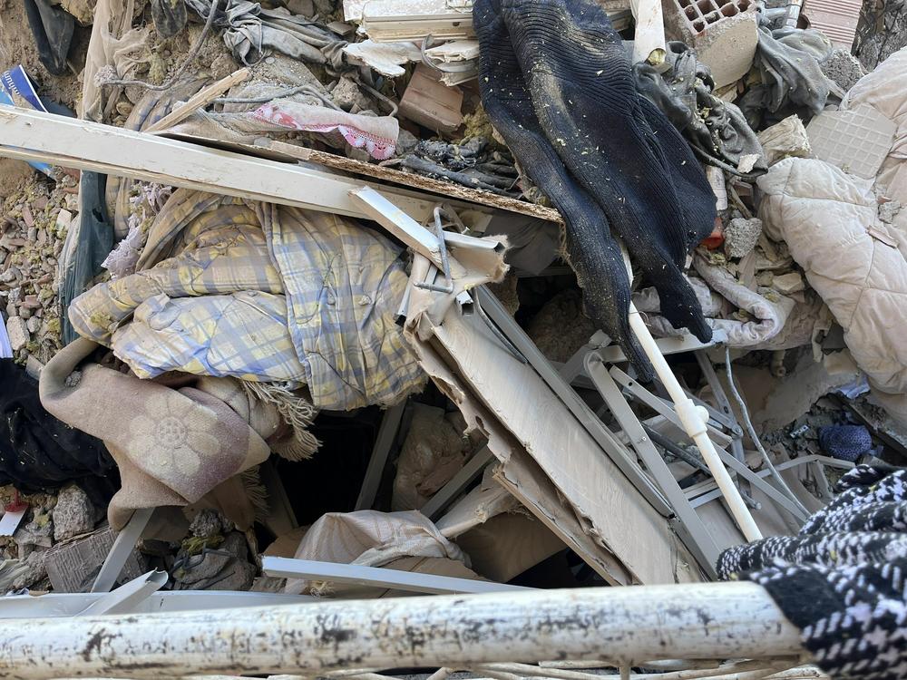 Ali and Merve Kafadenk's mangled bed frame sits atop the rubble of their destroyed apartment in Islahiye, Turkey. When the earthquake hit Feb. 6, the bedroom walls caved in, forming a concrete tent over their bed and protecting them.