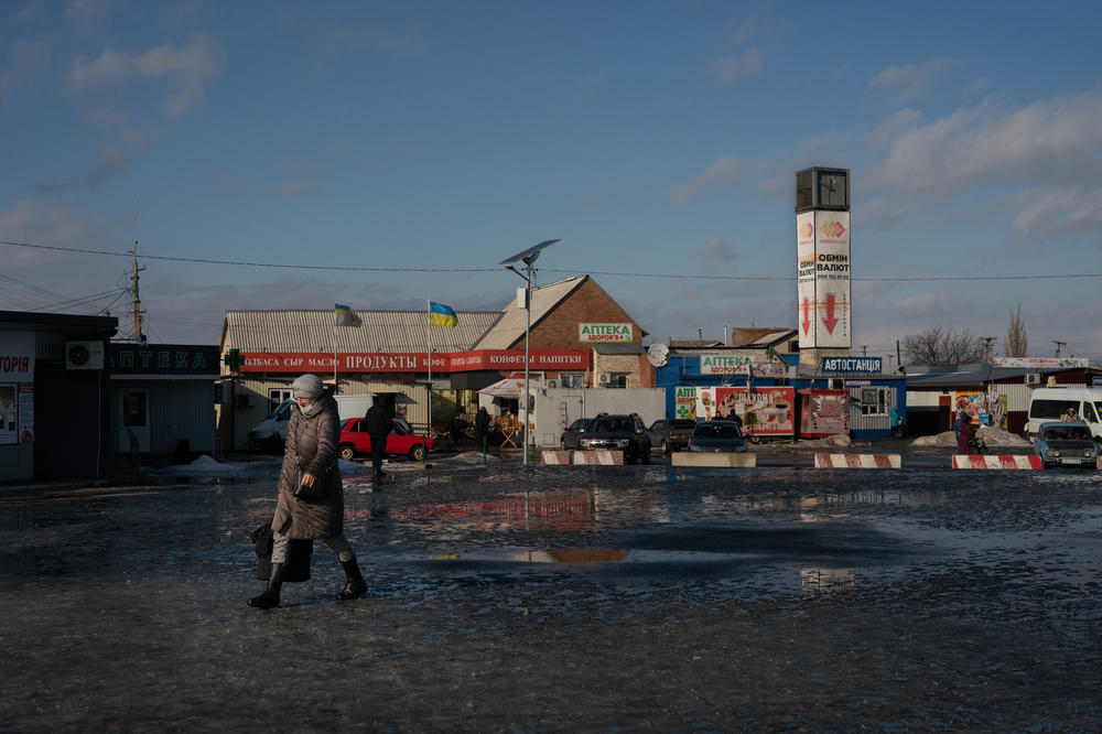 In January 2022, a woman walks toward what was the only crossing between the rest of Ukraine and the northernmost occupied territory, manned by guards on both sides who check documents in Stanytsia Luhanska, in eastern Ukraine.