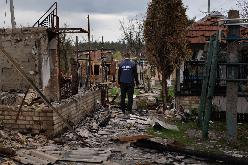 Pavlo Rebenko, a Ukrainian war crimes prosecutor, enters the rubble around a house to look at a human skeleton in Moshchun in April.