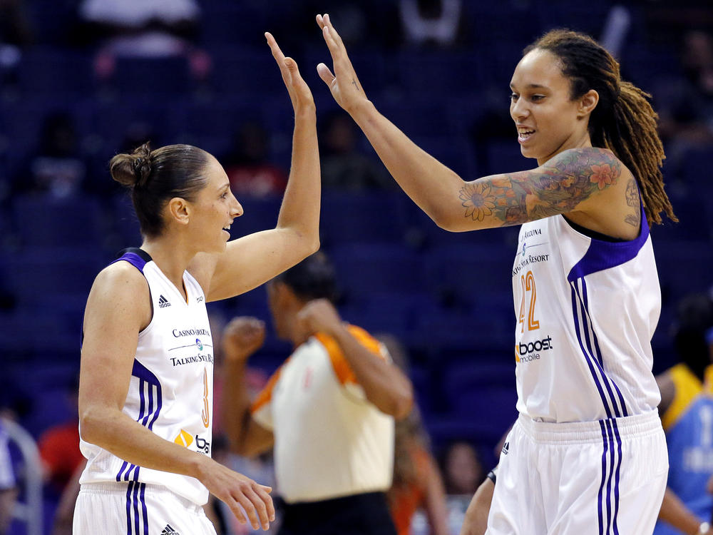 Phoenix Mercury guard Diana Taurasi, left, high-fives teammate Brittney Griner during a 2014 WNBA basketball game in Phoenix. Griner plans to return to the Mercury on a one-year contract.