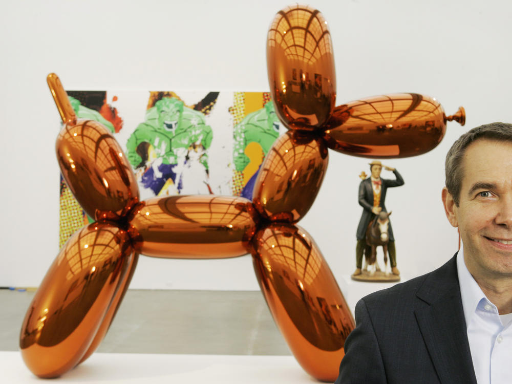 Artist Jeff Koons poses beside one of his balloon dog works, on display at Chicago's Museum of Contemporary Art in 2008.