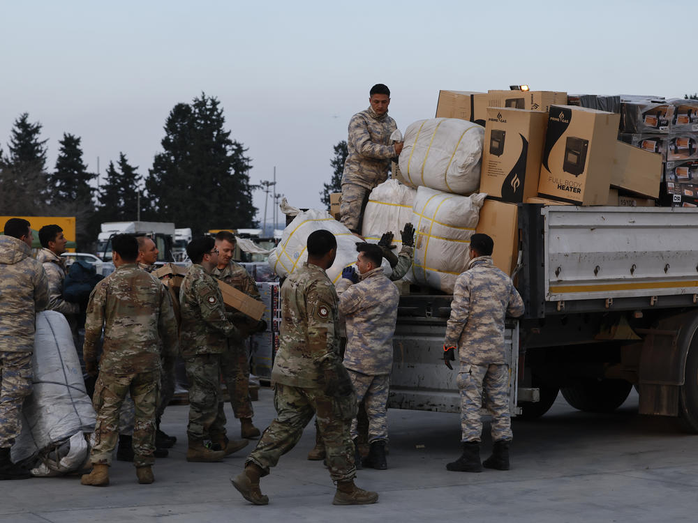 Troops load aid onto a vehicle as U.S. Secretary of State Antony Blinken visits Incirlik Air Base near Adana, Turkey, on Sunday.
