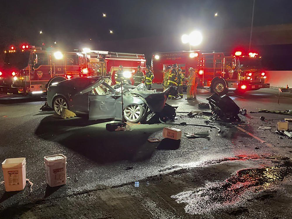 Fire officials said the Tesla driver was killed and a passenger was critically injured Saturday when the car plowed into the firetruck parked on a Northern California freeway.
