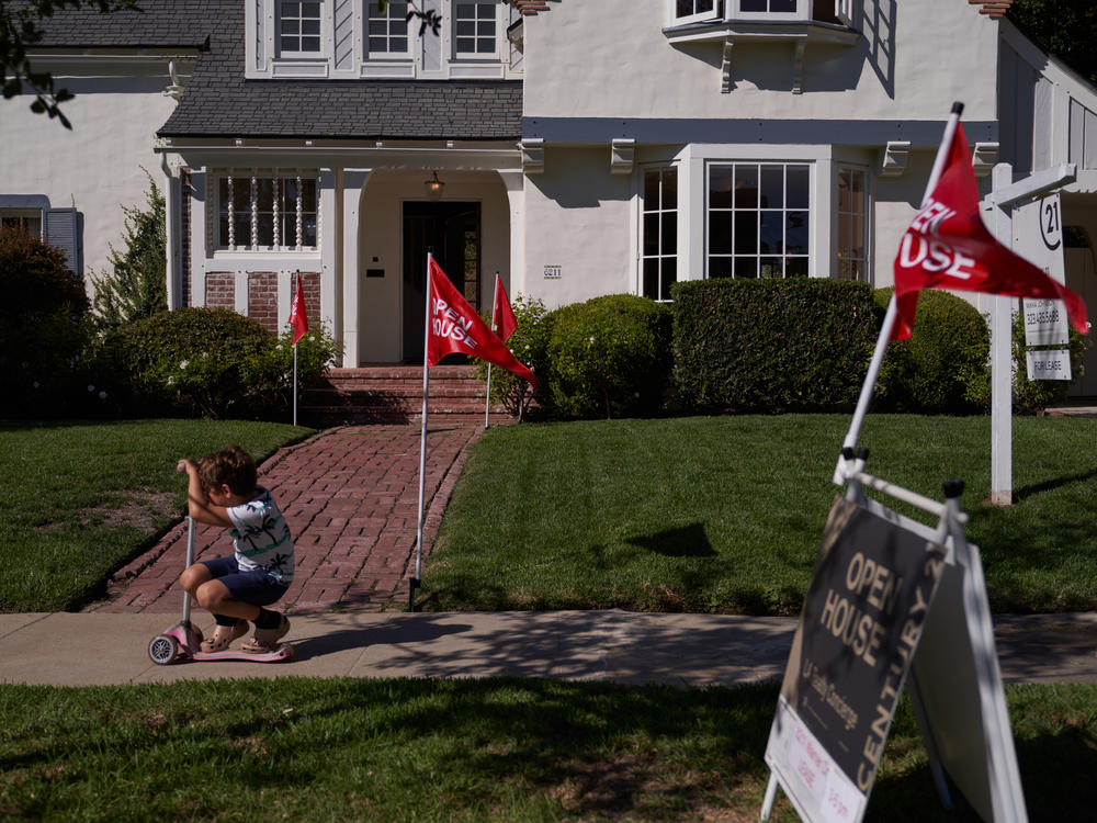 A child rides a scooter past an open house in Los Angeles.