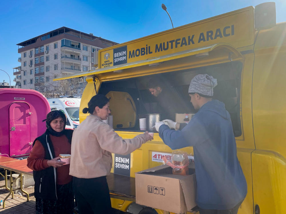At a tent encampment in the hard-hit city of Nurdagi, 28-year-old Aylin Kilinçli and her mother pick up two cups of lentil soup from volunteer chefs. 