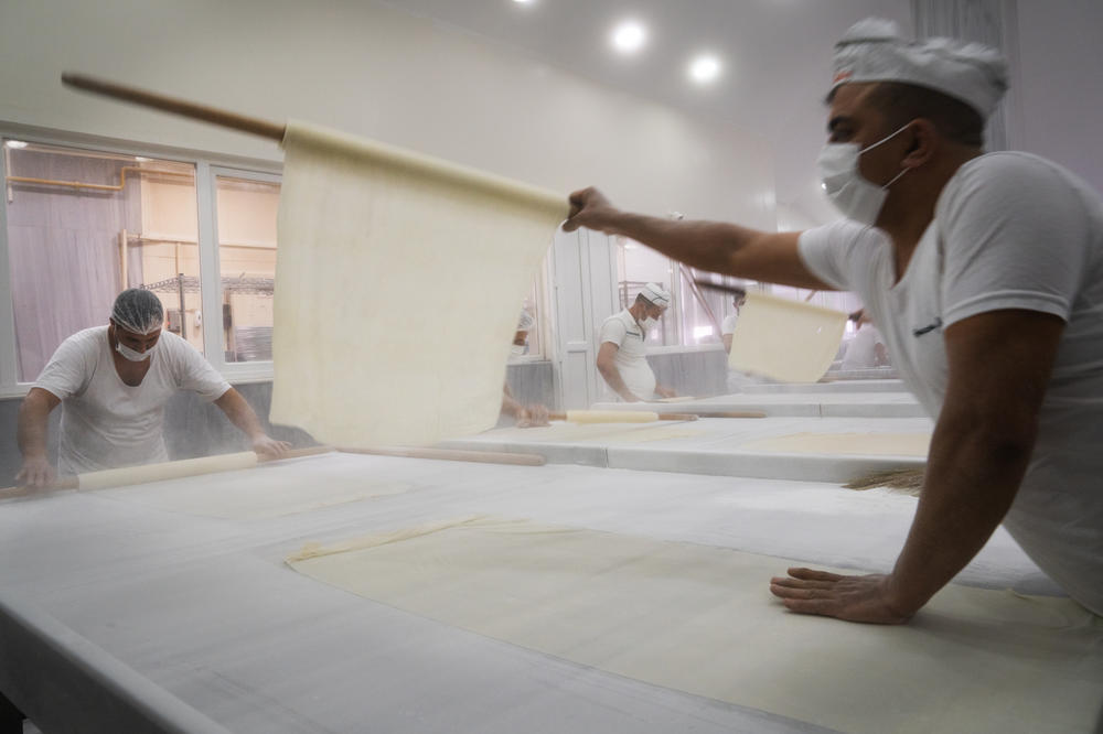 Pastry is rolled on a marble surface while making baklava at Imam Cagdas.