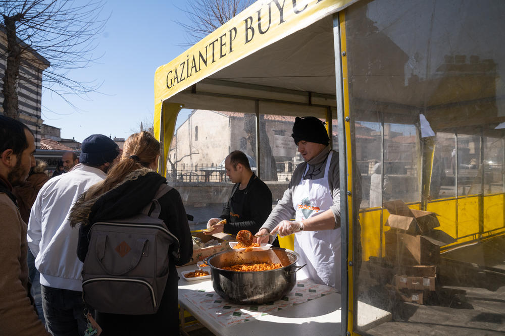 A tent outside the restaurant serves free food to people who need a meal.