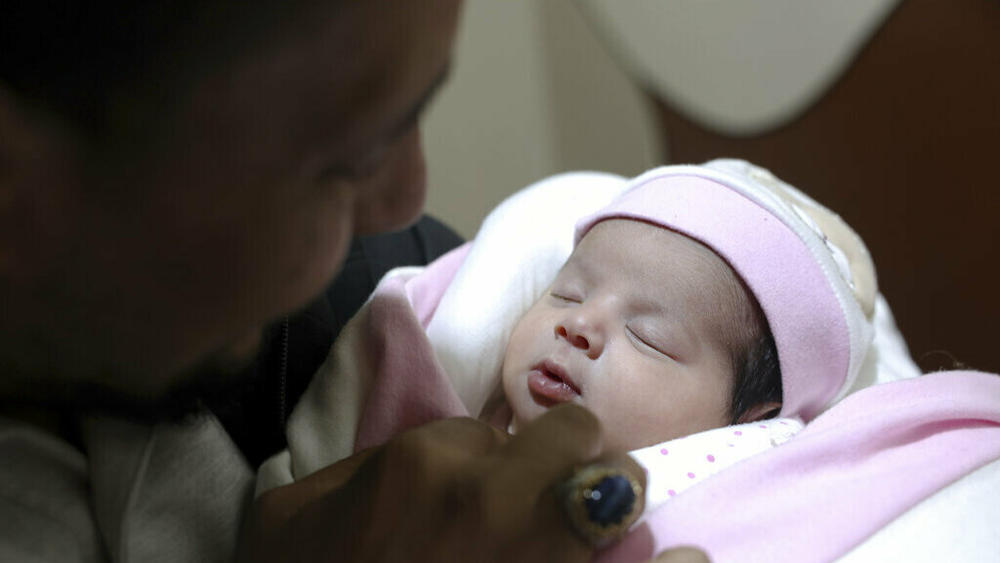 Khalil al-Sawadi looks Monday at Afraa, a baby girl who was born under the rubble caused by an earthquake that hit Syria and Turkey, in the town of Jinderis, Aleppo province, Syria.