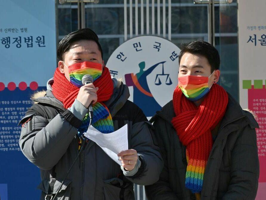 So Seong-uk, left, speaks at a press conference while his partner Kim Yong-min looks on in February 2021 as they file a lawsuit against South Korea's National Health Insurance Service at the Seoul Administrative Court.