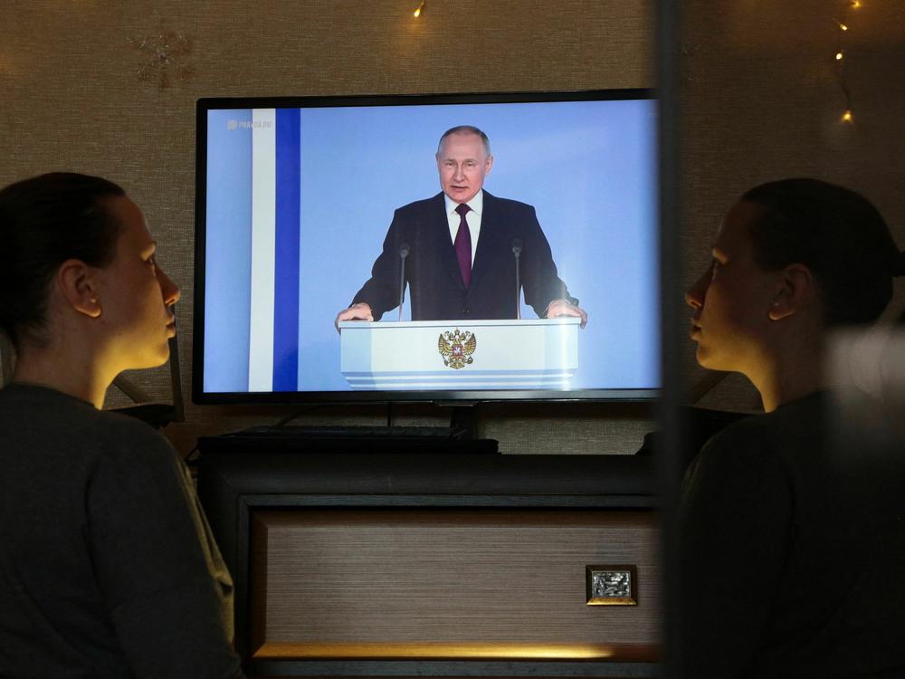 A woman in Simferopol, Crimea, watches a TV broadcast of Russian President Vladimir Putin's annual state of the nation address on Tuesday. Putin announced Russia is suspending participation in the New START nuclear weapons treaty.