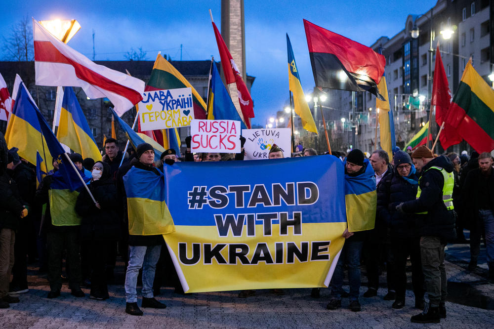 People hold flags and posters during a February 2022 protest against Russia's invasion of Ukraine, near the Lithuanian Parliament in Vilnius, Lithuania.