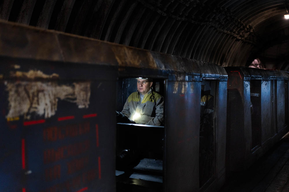 An employee at a coal mine in eastern Ukraine travels deep into the mine during the summer.
