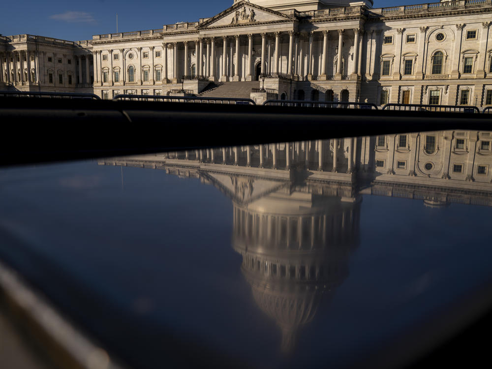 The dome of the U.S. Capitol building is visible in a reflection on Capitol Hill in Washington, D.C., Jan. 23, 2023.