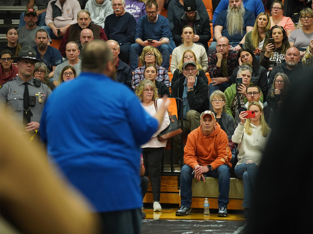 Community members listen to East Palestine Mayor Trent Conaway during a town hall meeting last week.