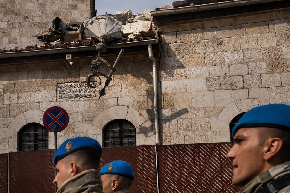 Military personnel walk in front of Habib-i Najjar Mosque in Antakya.
