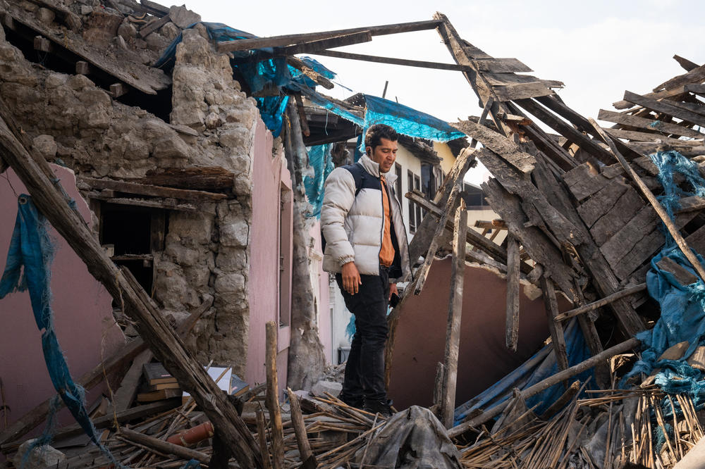 Yusuf Kocaoglu stands in the wreckage of buildings damaged by the earthquake in Antakya, Turkey, as he tries to walk through the city where he used to give history tours.