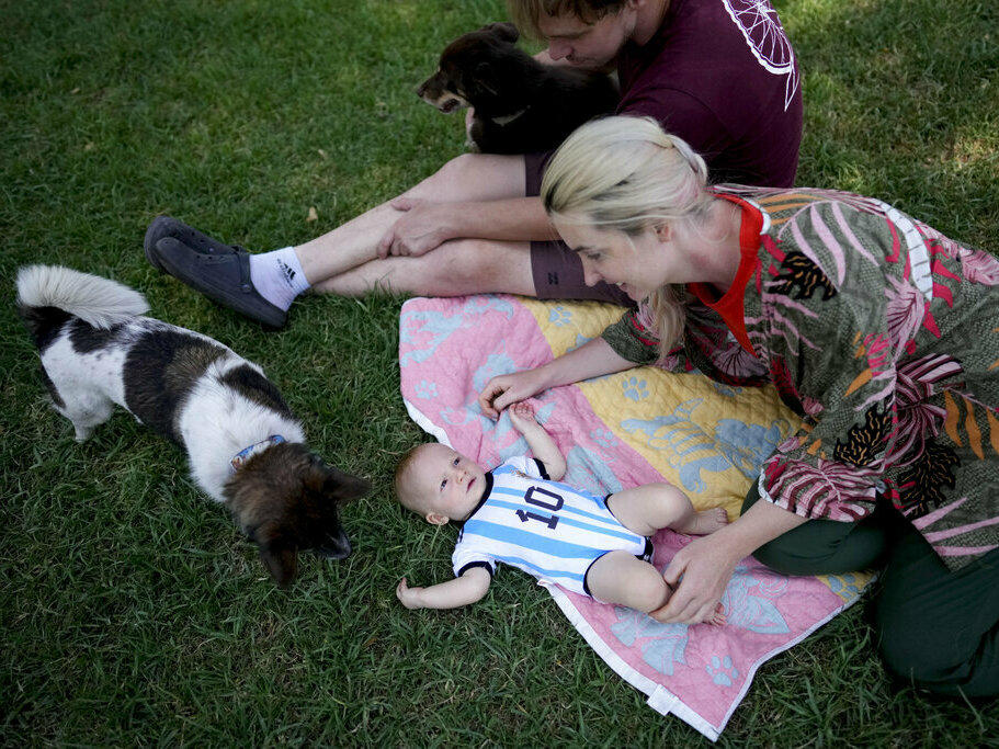 Russian nationals Alla Prigolovkina, her husband Andrei Ushakov, their Argentine-born son Lev Andres and their dogs Santa and Cometa visit a park Feb. 14 in Mendoza, Argentina. In spite of the language barrier and the stifling summer heat, Prigolovkina and Ushakov have quickly adopted Argentine customs since their July move.