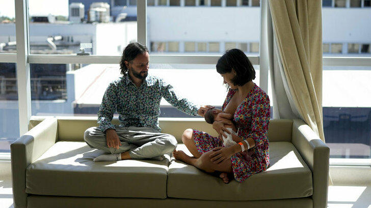 Maxim Levoshin sits with his wife Ekaterina Gordienko on Feb. 18 as she breastfeeds their newborn son, Leo, in Buenos Aires, Argentina. Gordienko and Levoshin arrived in the Argentine capital in December.