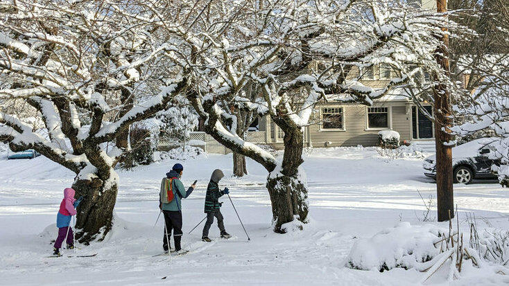 People make their way through a snow-covered street in the Grand Park neighborhood of Portland, Ore., on Thursday. The city experienced its second snowiest day on record.